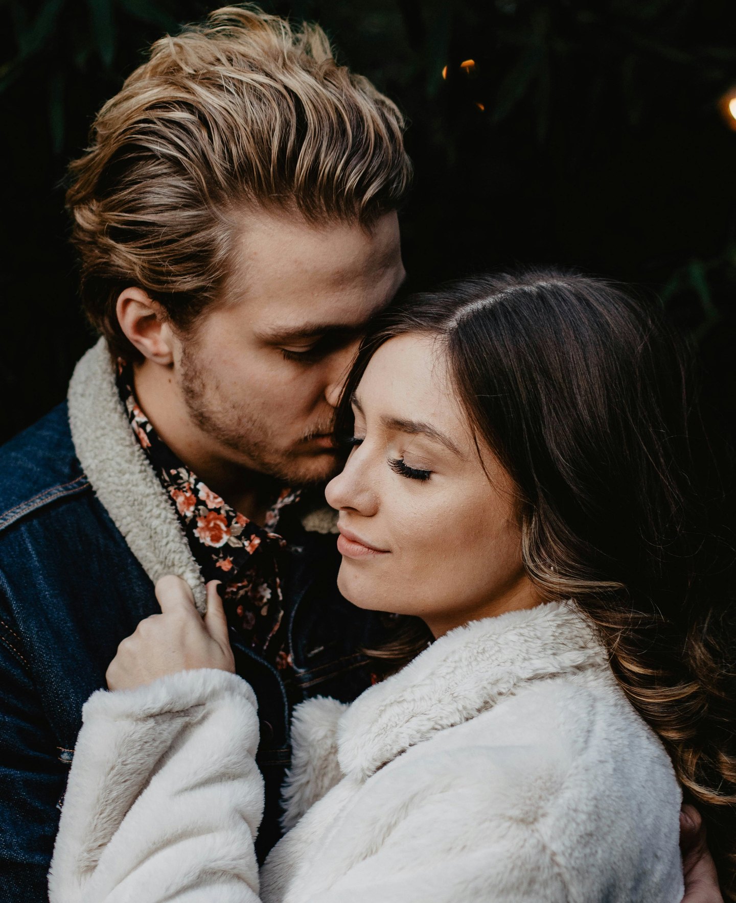 A couple holding one another closely, eyes closed.