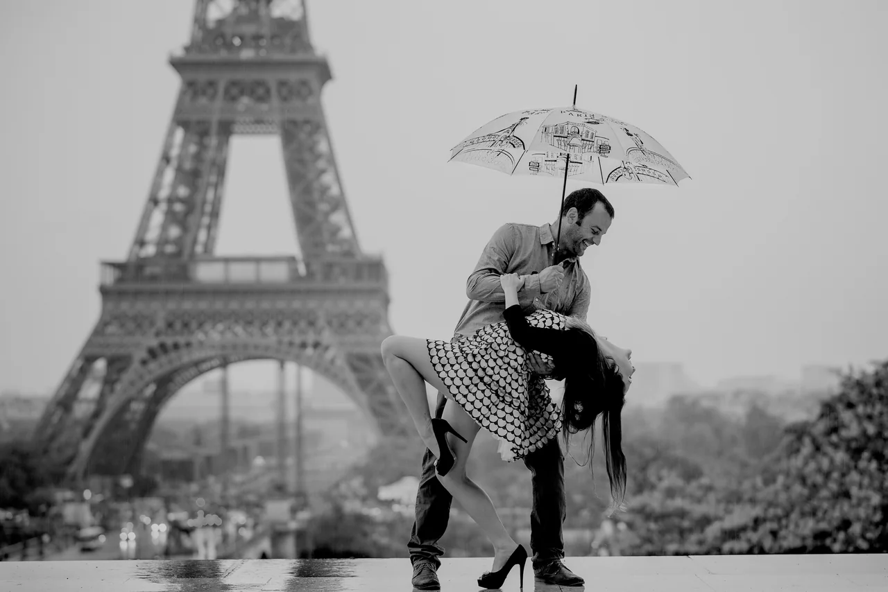 A couple dancing under an umbrella in the rain in Paris.