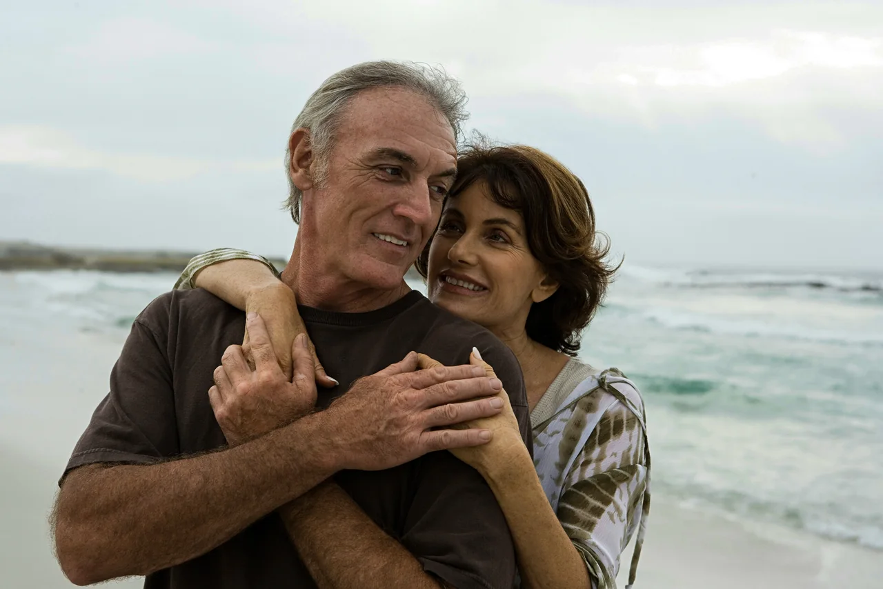 A couple embracing on a beach.
